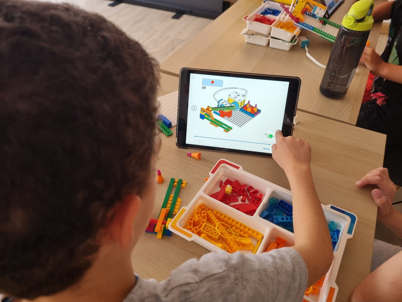 Kind programmiert Roboter auf iPad